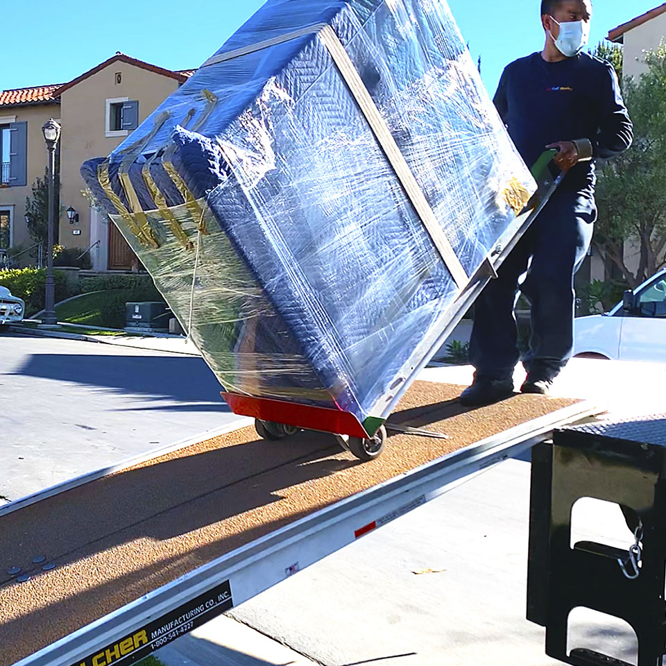 A local mover loading a furniture piece onto our moving truck.