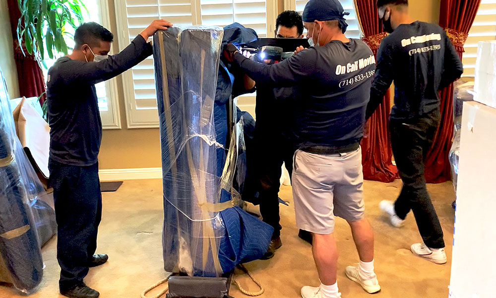 Our movers wrapping a piano.