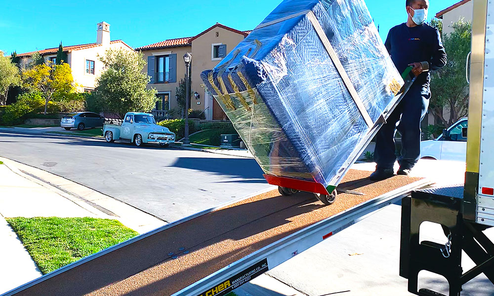 One of our movers moving a furniture piece onto our moving truck.